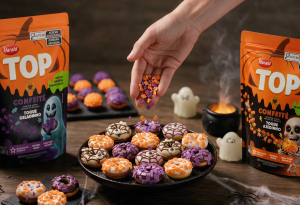 Brigadeiros e cupcakes finalizados com Confeité TOP roxo e laranja de Halloween em uma vitrine temática